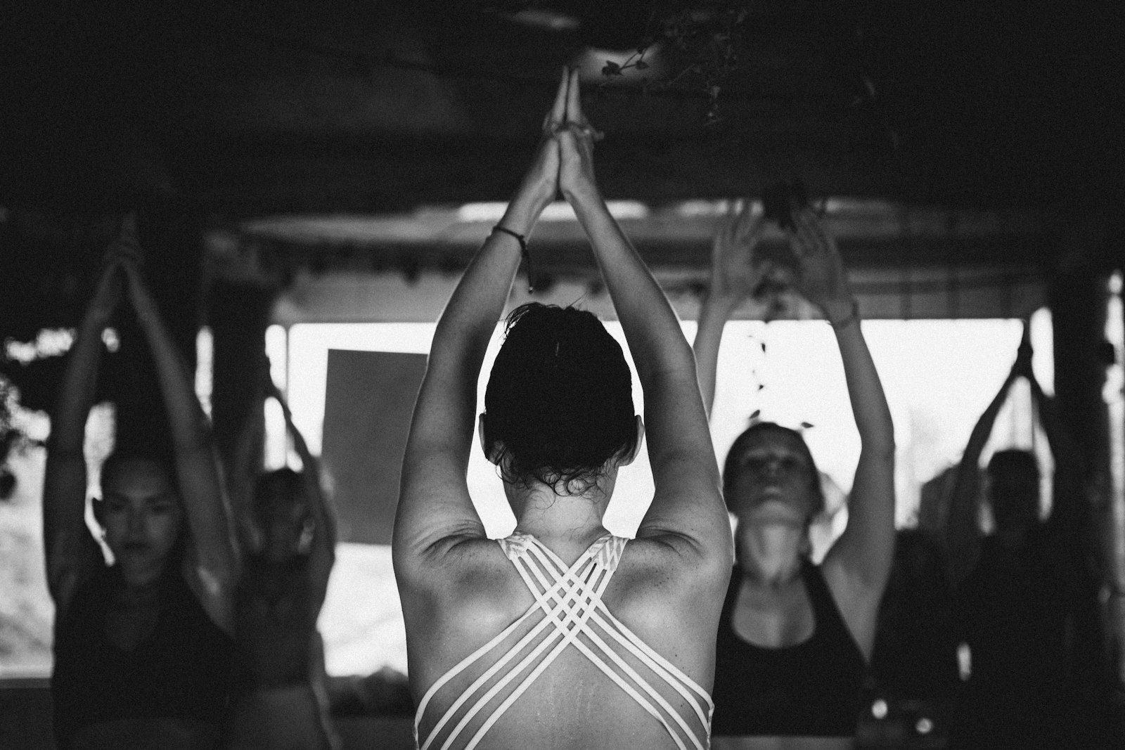 Group of women practicing yoga together in a sunlit studio room